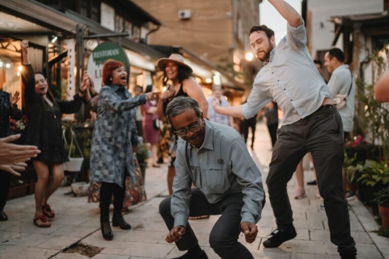 Trafalgar guests attempt Sribash dancing at a traditional Bosnian dinner e1721285495188