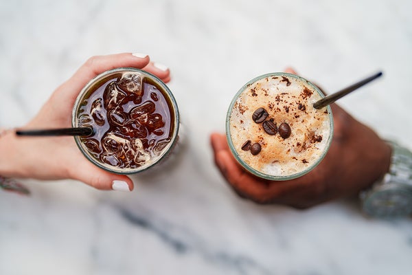 Two hands holding coffee drinks