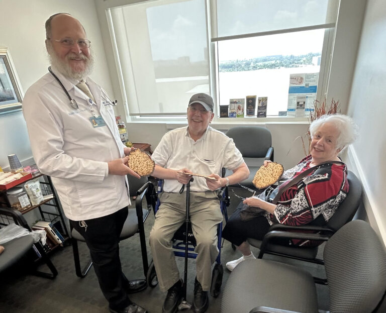Dr Levin gives matzah to Isaac and Joelle Zimbalist